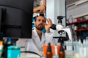 Scientist preparing microscope slide for experiment in laboratory